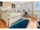 Sunlit bedroom featuring a bed, desk and multiple windows overlooking a wooded outdoor space at 1326 Lochshire Dr, Burlington, NC 27215
