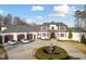 Stately home with circular driveway, water feature, attached three-car garage, and manicured landscaping at 1326 Lochshire Dr, Burlington, NC 27215
