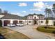 Stately home boasts a circular driveway and a manicured lawn with mature trees at 1326 Lochshire Dr, Burlington, NC 27215