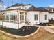 Exterior view of the home featuring a sunroom and landscaped yard with small dog at 1326 Lochshire Dr, Burlington, NC 27215