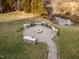 An aerial view of a stone patio with a fire pit, seating, and a built-in grill at 1326 Lochshire Dr, Burlington, NC 27215
