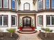 Elegant front entrance with mature landscaping and a decorative leaded glass door at 1326 Lochshire Dr, Burlington, NC 27215