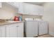Bright laundry room features white cabinetry, granite countertops, sink and modern washer and dryer at 1326 Lochshire Dr, Burlington, NC 27215
