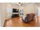 Comfortable living room with fireplace, large windows, ceiling fan, and hardwood flooring at 1326 Lochshire Dr, Burlington, NC 27215