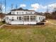 Stately white home featuring a walkout terrace, sunroom, and manicured landscaping at 1326 Lochshire Dr, Burlington, NC 27215
