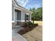 The exterior detail shows manicured landscaping with vibrant red flowers and brick foundation at 135 Baneberry Dr, Broadway, NC 27505