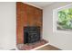 Basement with brick fireplace and stove insert, offering a cozy focal point at 1411 Rosewood St, Durham, NC 27701
