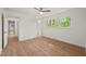 Bright bedroom featuring a ceiling fan, light hardwood floors, and a large window providing plenty of natural light at 1411 Rosewood St, Durham, NC 27701
