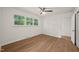 Bright bedroom with ceiling fan, light hardwood floors, and a large window offering great natural light at 1411 Rosewood St, Durham, NC 27701
