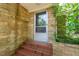 Charming home entrance with brick steps, masonry siding, and a glass and mesh front door at 1411 Rosewood St, Durham, NC 27701