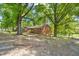 Charming red brick home with a cozy front porch, surrounded by mature trees at 1411 Rosewood St, Durham, NC 27701