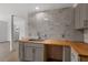 Updated kitchen showcases butcher block counters, stainless sink and marble backsplash at 1411 Rosewood St, Durham, NC 27701