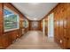 Spacious living room featuring wood paneling, a large window, and light hardwood floors at 1411 Rosewood St, Durham, NC 27701