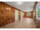 Spacious living room featuring wood paneling, a large window, and light hardwood floors at 1411 Rosewood St, Durham, NC 27701