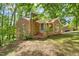 Quaint brick home with a brick and stone chimney and mature trees in the backyard at 1411 Rosewood St, Durham, NC 27701