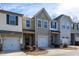 View of townhomes with complementary siding, attached garages, and well-maintained front yards at 14312 Foxcroft Rd, Raleigh, NC 27614