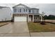 Charming two-story home with a stone facade, blue siding, manicured lawn, and a two-car garage at 149 Ethel Ln, Angier, NC 27501