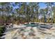 Backyard with a pool, patio furniture, and a serene, private setting surrounded by trees at 1520 Grand Willow Way, Raleigh, NC 27614