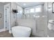 Bright bathroom featuring a soaking tub, glass shower, and marble tile at 1520 Grand Willow Way, Raleigh, NC 27614