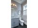 Bright bathroom with a gray vanity, white toilet, and natural light from a window at 1520 Grand Willow Way, Raleigh, NC 27614