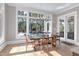 Bright dining room featuring wood floors, a modern chandelier, and views of the outdoor pool and wooded lot at 1520 Grand Willow Way, Raleigh, NC 27614