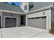 Home exterior with multiple garage doors, gray siding, and a well-manicured lawn at 1520 Grand Willow Way, Raleigh, NC 27614