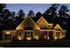 Inviting home exterior at dusk, beautifully illuminated by landscape lighting, showcasing its architectural details at 1520 Grand Willow Way, Raleigh, NC 27614