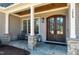 Charming front porch with stone accents, a wood ceiling, and a cozy seating area at 1520 Grand Willow Way, Raleigh, NC 27614