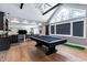 Large game room is fitted with a stylish pool table, kitchenette, and vaulted ceiling with a large window at 1520 Grand Willow Way, Raleigh, NC 27614