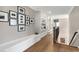 Upstairs hallway featuring hardwood floors, built in bookcase and framed photos at 1520 Grand Willow Way, Raleigh, NC 27614