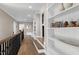 Hallway with beautiful hardwood floors, open staircase, white built-in shelving, and elegant details at 1520 Grand Willow Way, Raleigh, NC 27614