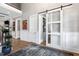 Spacious hallway featuring hardwood floors, high ceilings, and a modern sliding barn door at 1520 Grand Willow Way, Raleigh, NC 27614