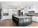 Bright kitchen features a large island with seating, modern appliances, and hardwood floors at 1520 Grand Willow Way, Raleigh, NC 27614
