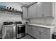 Laundry room featuring stainless steel washer and dryer plus ample storage space at 1520 Grand Willow Way, Raleigh, NC 27614