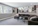 Open-concept living room boasts a large sectional, a mounted TV, and large windows for natural light at 1520 Grand Willow Way, Raleigh, NC 27614