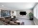 Relax in this cozy living room with a comfortable sectional sofa, mounted TV, and neutral tones at 1520 Grand Willow Way, Raleigh, NC 27614