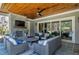 Stylish outdoor seating area with stone fireplace, ceiling fan, and view of the backyard and pool at 1520 Grand Willow Way, Raleigh, NC 27614
