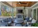 Inviting outdoor living space featuring a stone fireplace, ceiling fan, and comfortable seating area at 1520 Grand Willow Way, Raleigh, NC 27614