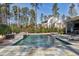 Beautiful in-ground pool with a stone surround, integrated spa and sun deck surrounded by mature trees at 1520 Grand Willow Way, Raleigh, NC 27614