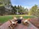 Inviting backyard with brick patio and four Adirondack chairs surrounding a fire pit at 1617 Heritage Club Ave, Wake Forest, NC 27587