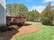 Spacious backyard with a wood deck, lush green lawn, and privacy trees at 1617 Heritage Club Ave, Wake Forest, NC 27587