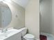 Neutral-toned bathroom featuring a white sink and toilet plus a round mirror and walk-in shower at 1617 Heritage Club Ave, Wake Forest, NC 27587