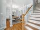 Light-filled dining room featuring hardwood floors, elegant columns, and a staircase at 1617 Heritage Club Ave, Wake Forest, NC 27587