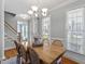 Bright dining room with a wooden table, chandelier, and large windows, creating an inviting space at 1617 Heritage Club Ave, Wake Forest, NC 27587