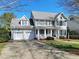 Charming two-story home featuring a welcoming front porch, attached two-car garage, and lush green lawn at 1617 Heritage Club Ave, Wake Forest, NC 27587