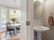 Half bath featuring pedestal sink, floral wallpaper, and wooden floors at 1617 Heritage Club Ave, Wake Forest, NC 27587