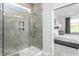 Modern bathroom featuring a glass-enclosed shower and an adjacent bedroom view at 1808 Angelonia Way, Fuquay Varina, NC 27526
