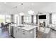 This open-concept kitchen boasts stainless steel appliances, a large island, and ample natural light, seamlessly flowing into the living area at 1808 Angelonia Way, Fuquay Varina, NC 27526