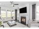 This bright living room features a fireplace, large windows, and comfortable seating, ideal for relaxing and entertaining guests at 1808 Angelonia Way, Fuquay Varina, NC 27526