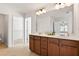 Bright bathroom with dual sinks, tile flooring, and doorway to walk-in closet at 2000 Muddy Creek Ct, Raleigh, NC 27610
